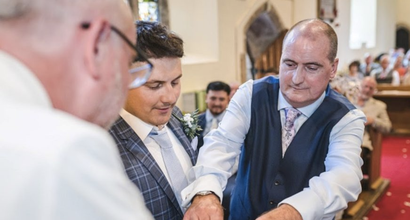 Lawrence, who was diagnosed with Hodgkin lymphoma, standing in front of a church congregation wearing a suit.